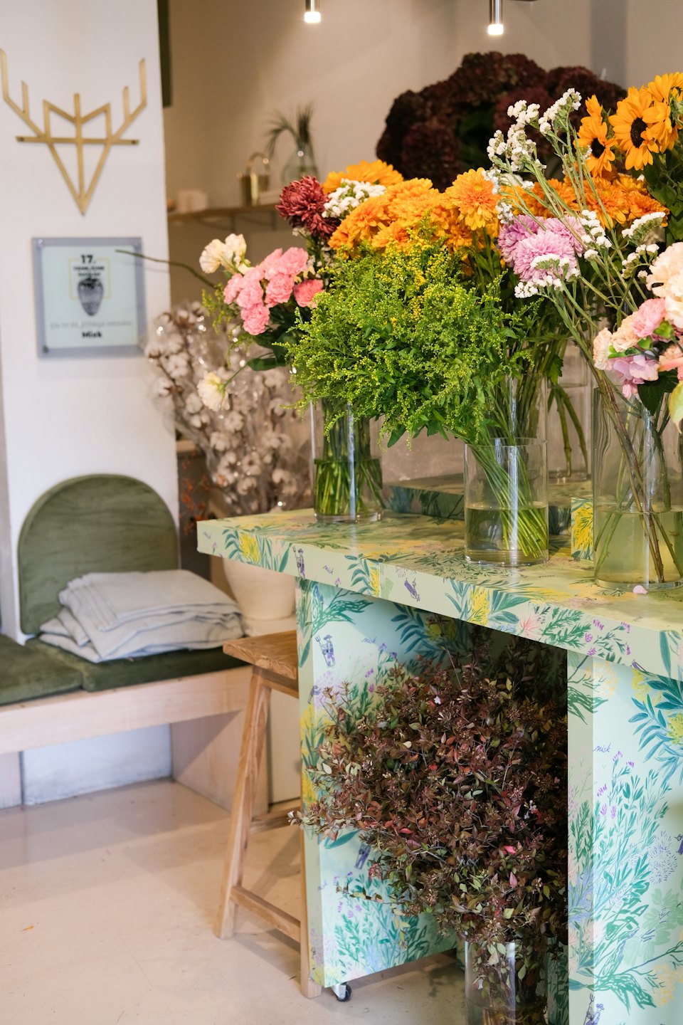 Colorful fresh cut flowers arranged in glass vases on a counter.