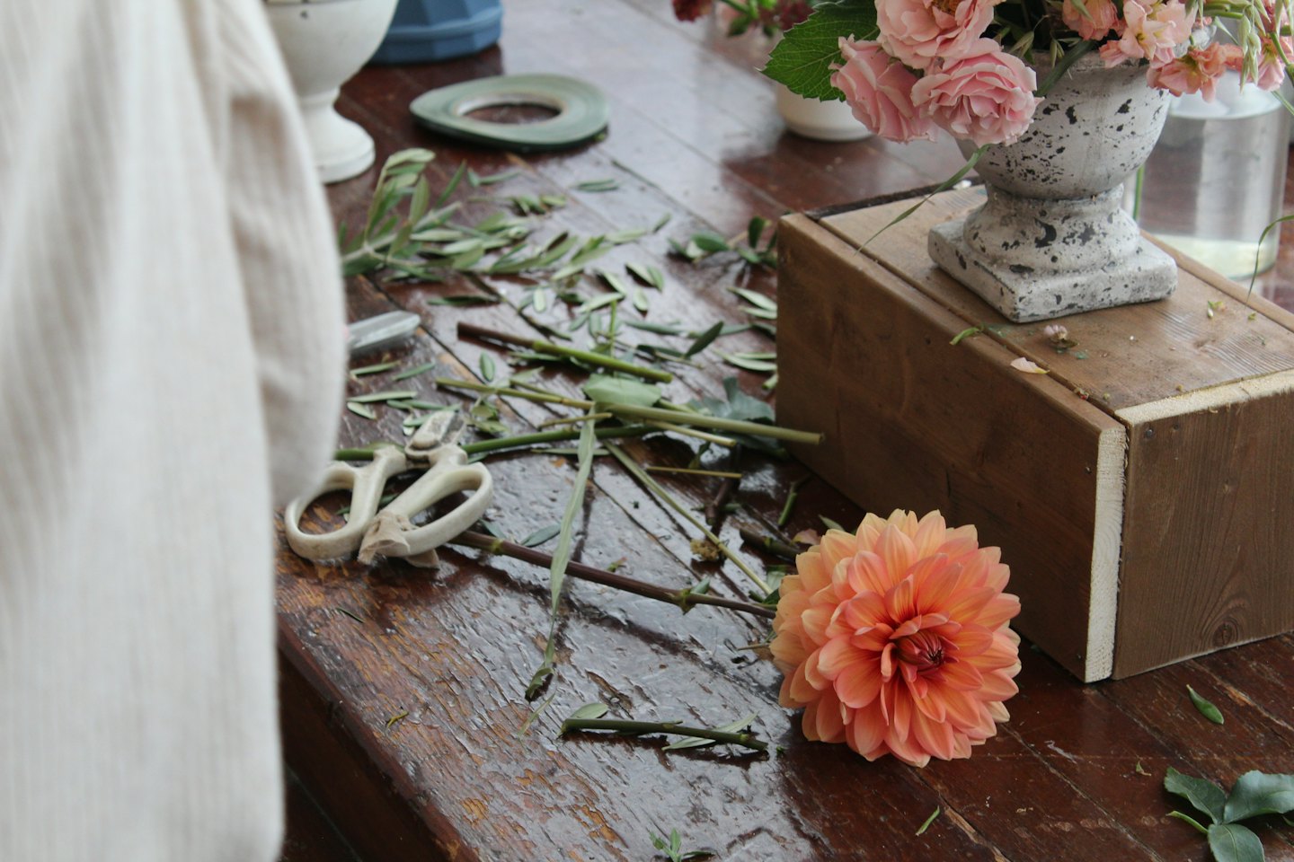 Florist's rustic table with dahlia, roses, and shears.