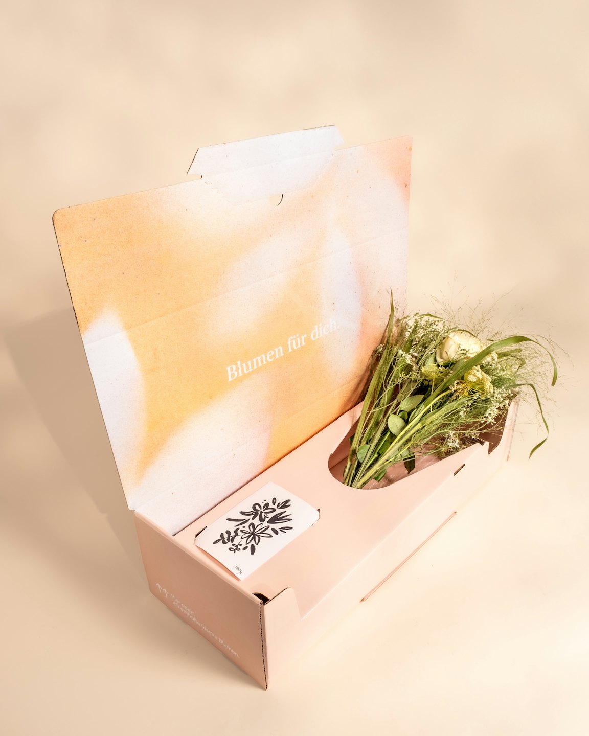 Flower bouquet in an open delivery box with an accessory card.