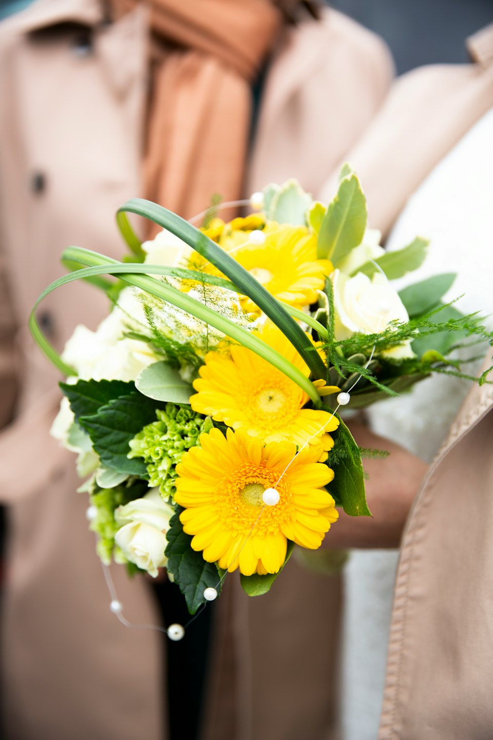 Yellow gerbera daisies and white roses in a wedding bouquet.